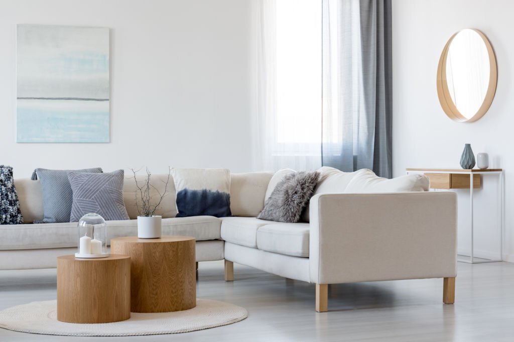 perabot Blue and white abstract painting and mirror in wooden frame in elegant living room interior with corner sofa and coffee table