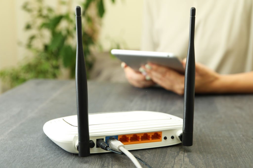 Wi – fi router on gray wooden table, close up Wi - fi router on gray wooden table, close up
